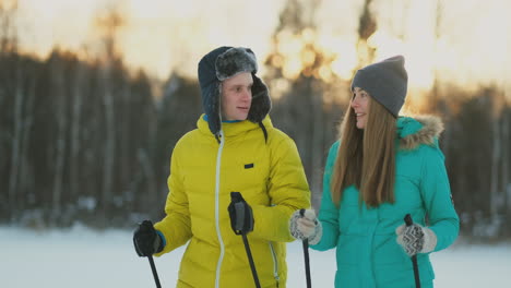 Full-length-portrait-of-caring-young-man-helping-injured-girlfriend-during-ski-walk-in-winter-forest